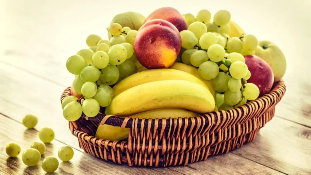 fruit basket with apples, grapes, and bananas