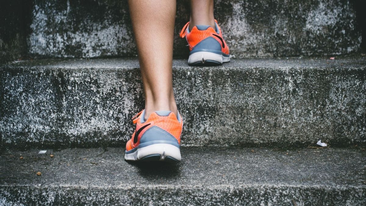 Photo of a person's feet in running shoes walking up the stairs