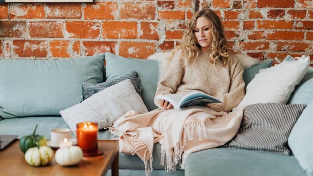 woman reading a book in a comfortable corner of house
