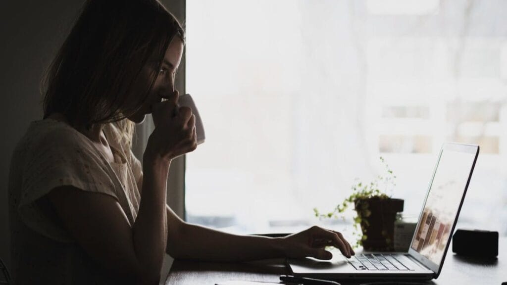 woman working on her laptop and drinking coffee