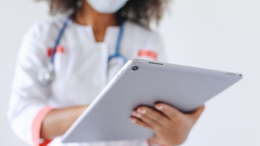 medical professional reading from a tablet.
