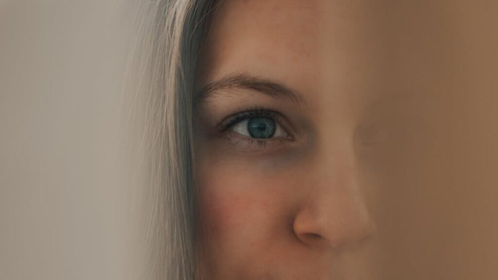 half face of a woman in focus and other half blurred; visual depiction of identity shift