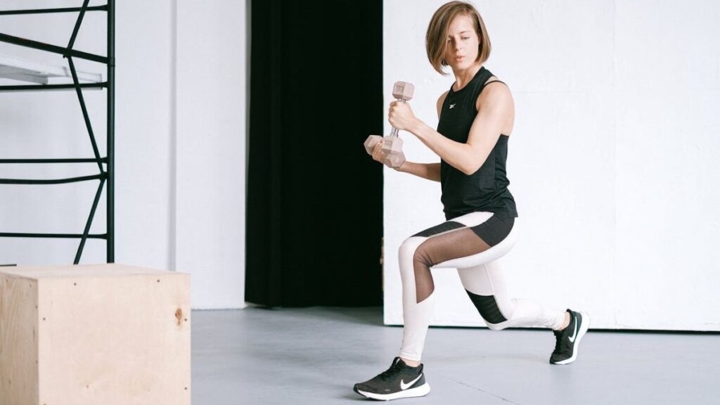woman doing workout from home with a pair of dumbbells